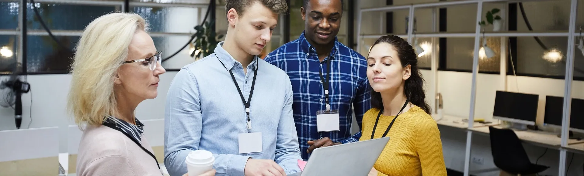 Colleagues reviewing information together on a laptop in a modern office.