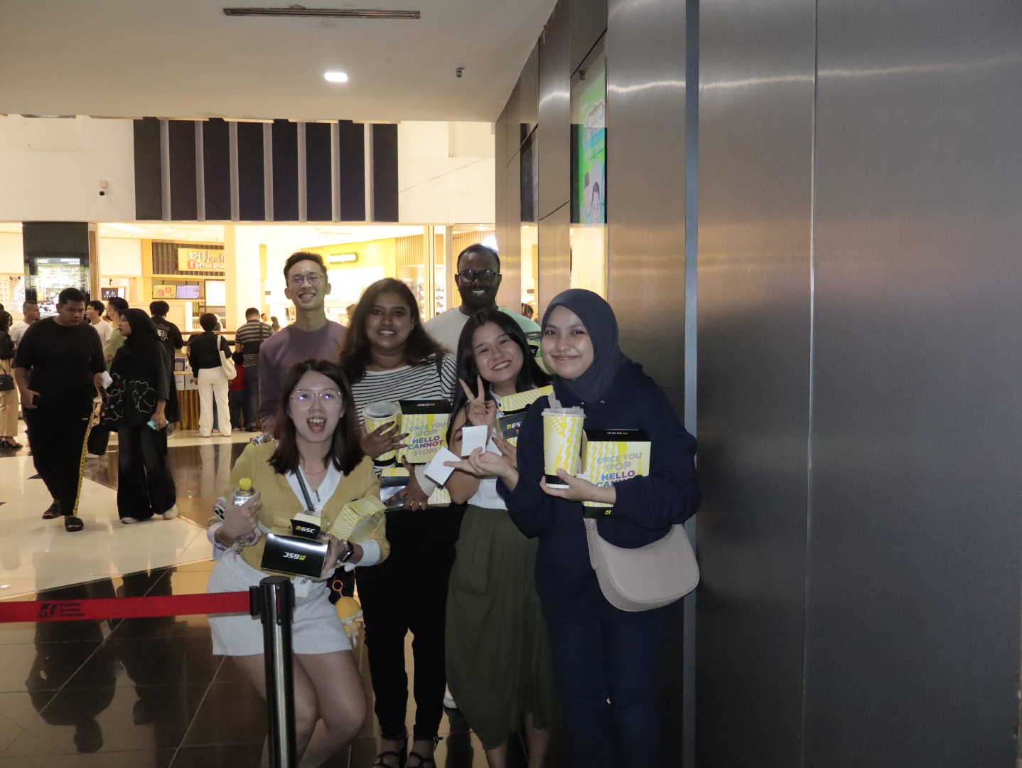 TP employees smiling and holding snacks in shopping mall