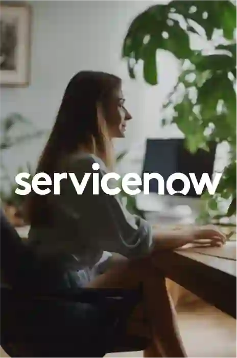 Service now logo in focus and a woman working on laptop 