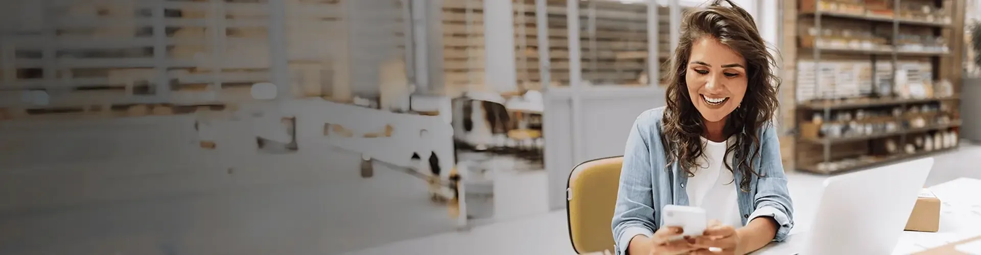 Woman smiling while looking at her phone at the office
