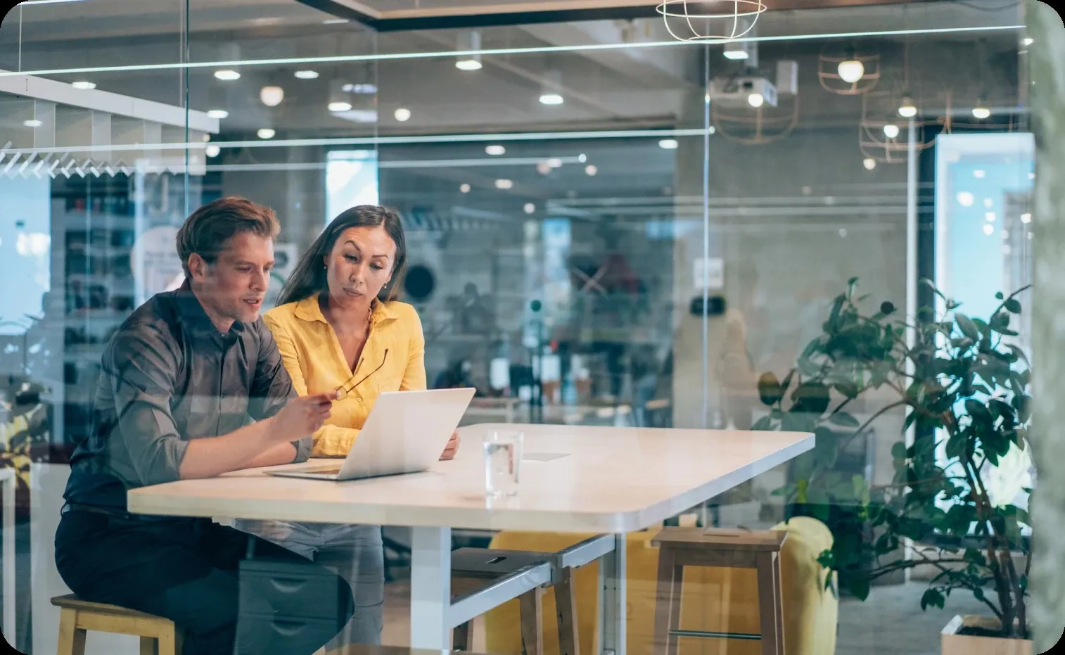 Colleagues having a meeting inside a modern glass walls office