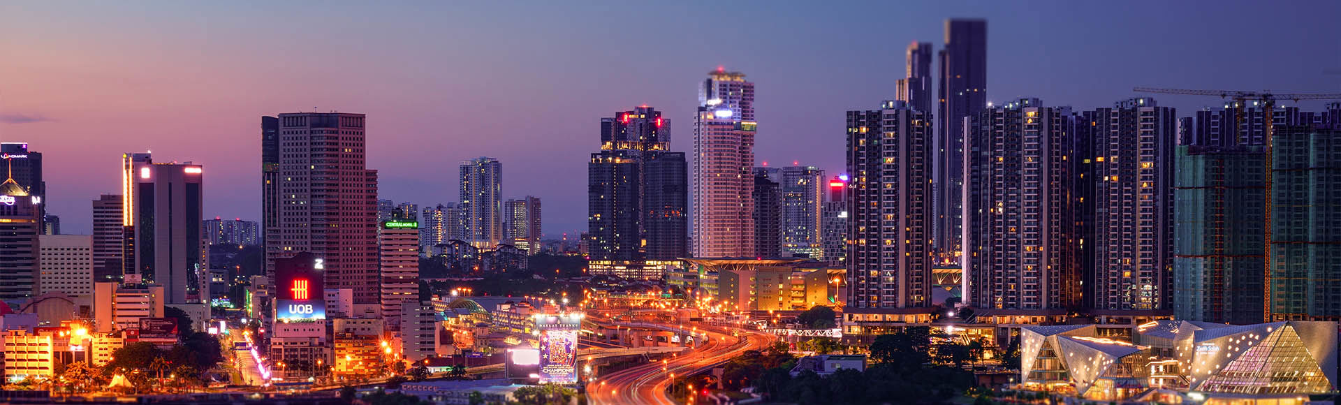Glowing Kuala Lumpur city skyline at beautiful dusk hour.