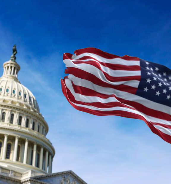 The U.S. Capitol building dome with the American flag prominently displayed, symbolizing national governance and public service initiatives.