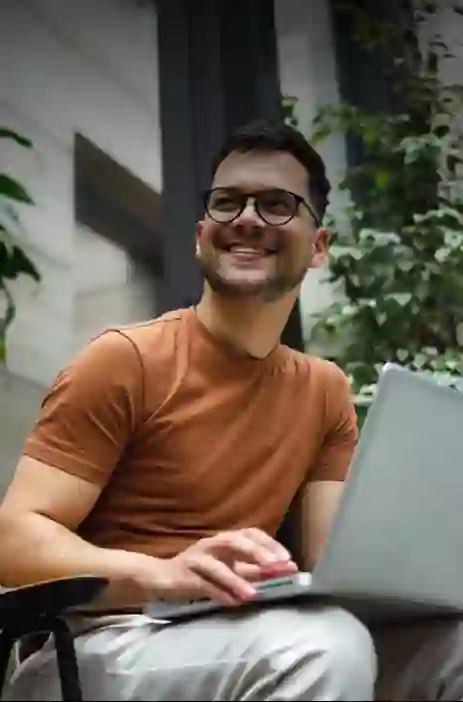 Man working on computer with trees in the background