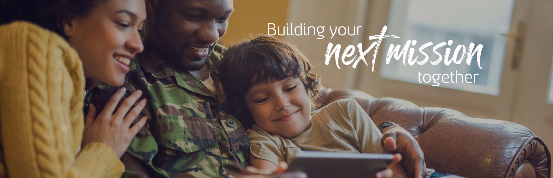a family sits on a couch, smiling and viewing a tablet together. the text reads, "building your next mission together." sunlight filters through a window in a cozy room.