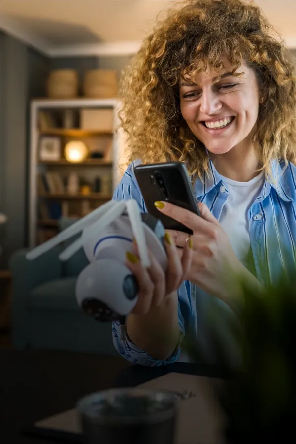 Smiling girl holding a smartphone in a casual setting.