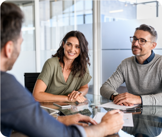 Insurance professionals in a modern office discussing client policies and documents during a business meeting around a glass table.