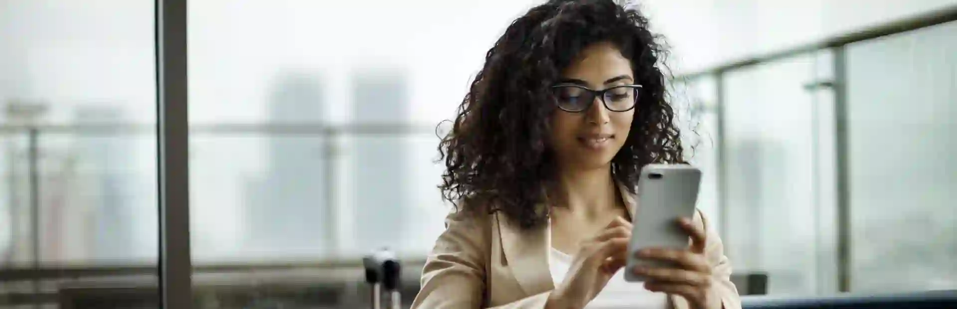 Young business woman reading news from her cellphone