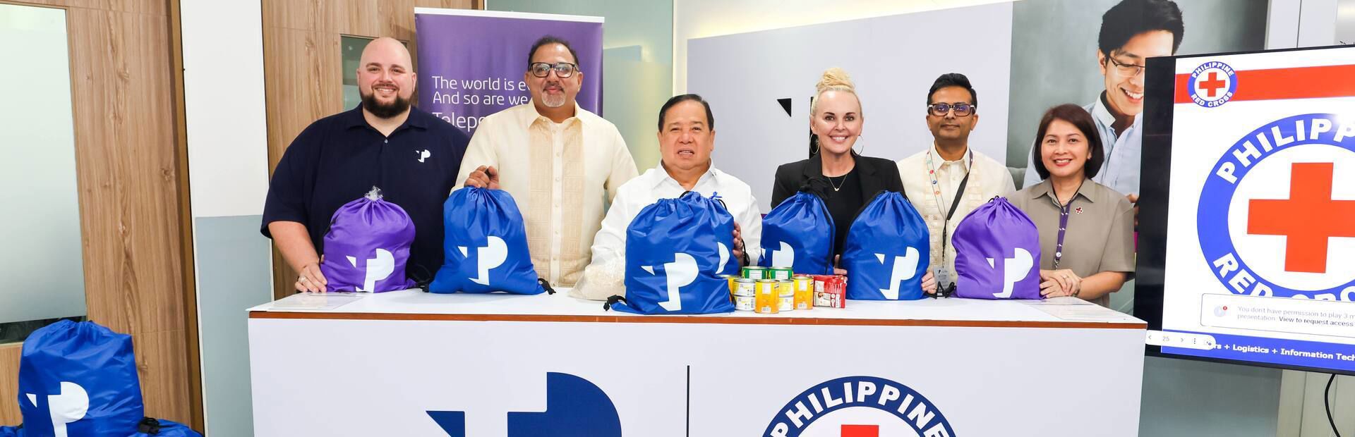 TP and Philippine Red Cross leaders unite in a symbolic packing activity for community support.