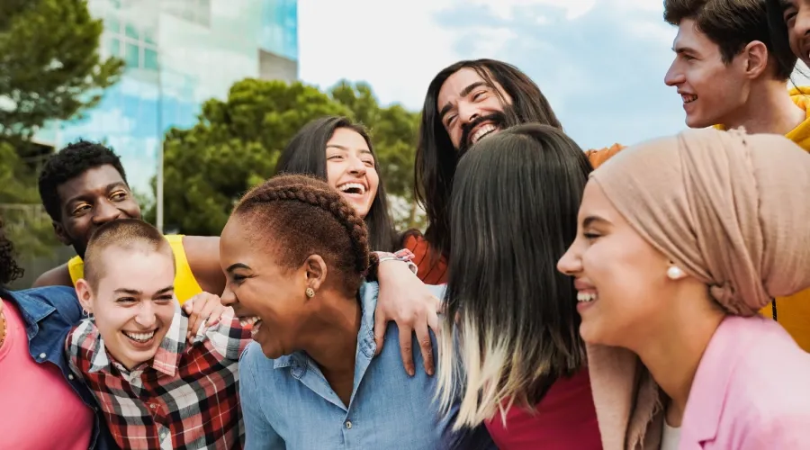 Diverse group of employees embracing, reflecting inclusion and team unity.