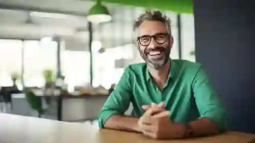 Smiling man wearing green shirt at an office