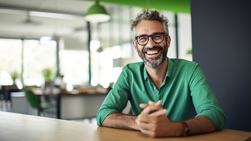 Smiling man wearing green shirt at an office