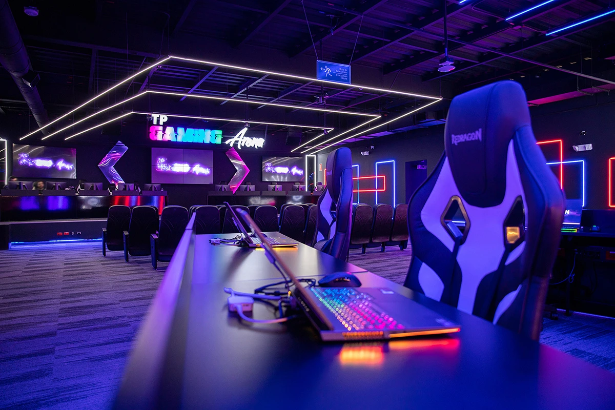 TP Gaming Arena with neon lights, gaming chairs, and RGB keyboards