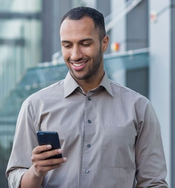 Giovane professionista utilizza lo smartphone in mobilità in un contesto urbano.