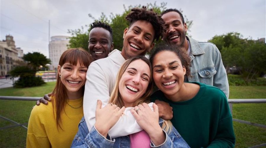 Diverse colleagues sharing a positive moment outdoors, reflecting teamwork.