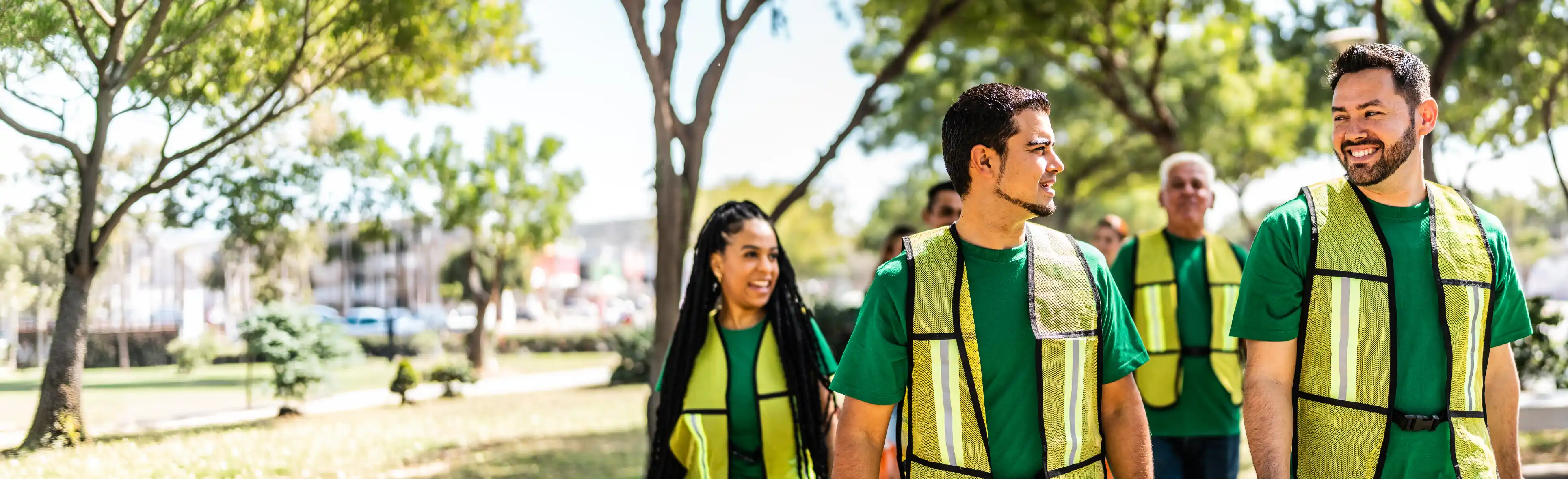 TP team members wearing safety vests walking together outdoors.