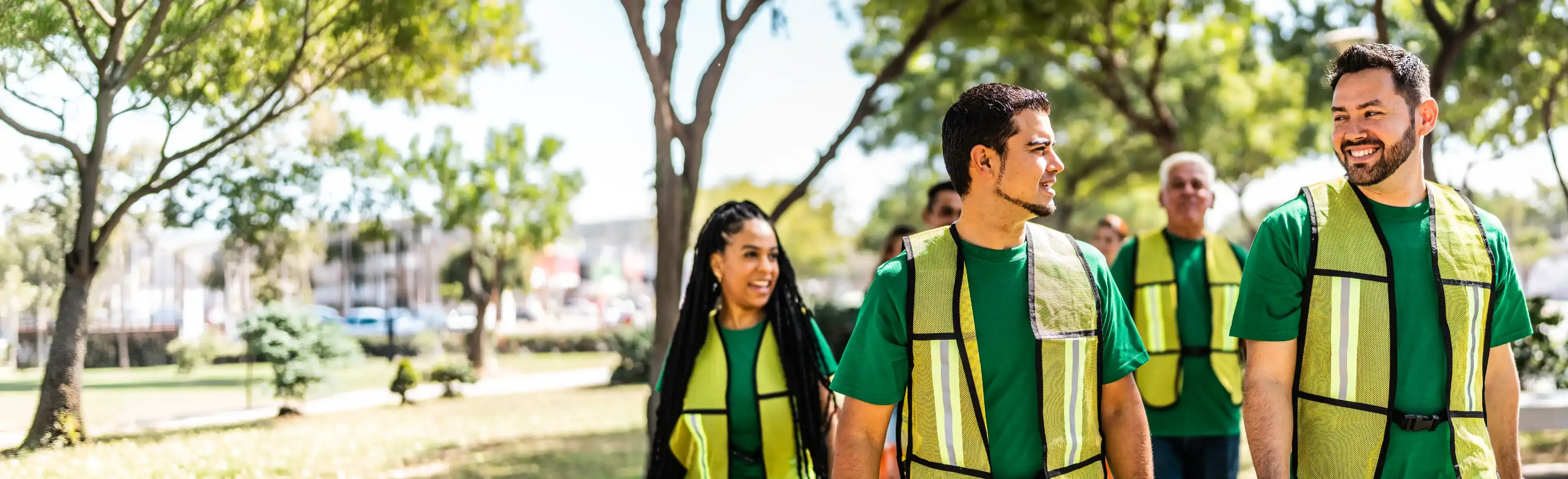TP team members wearing safety vests walking together outdoors.