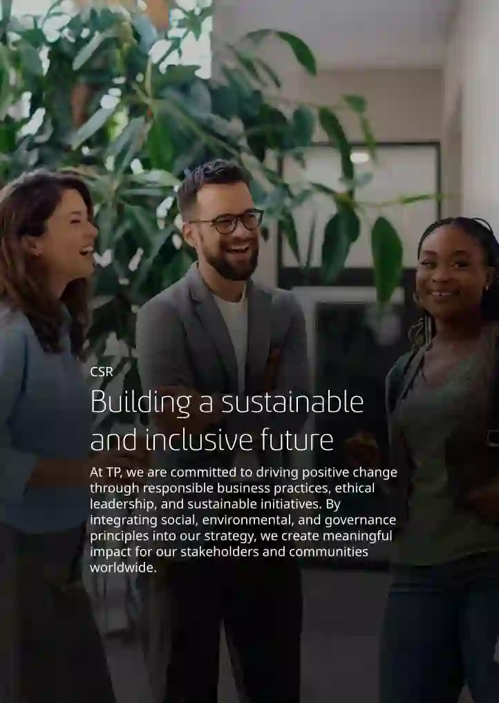 Group of employees talking and laughing in a modern, tree-lined office