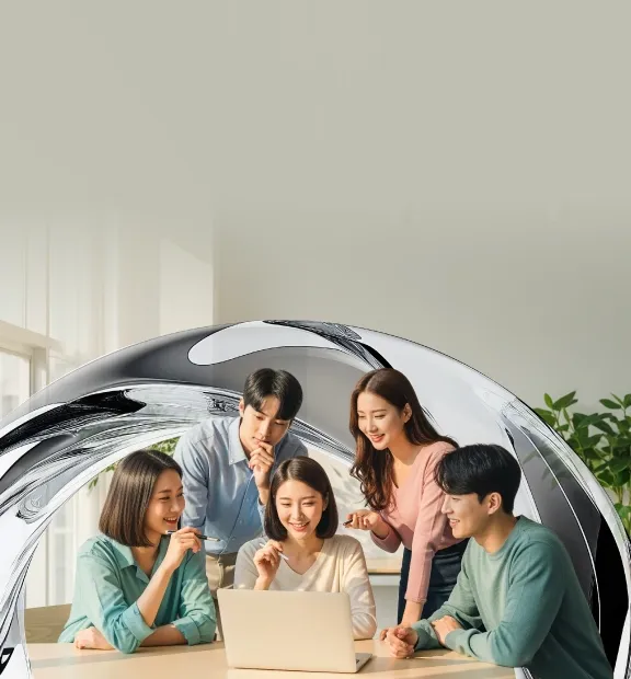 A diverse team of young professionals collaborates and discusses ideas around a laptop in a bright office