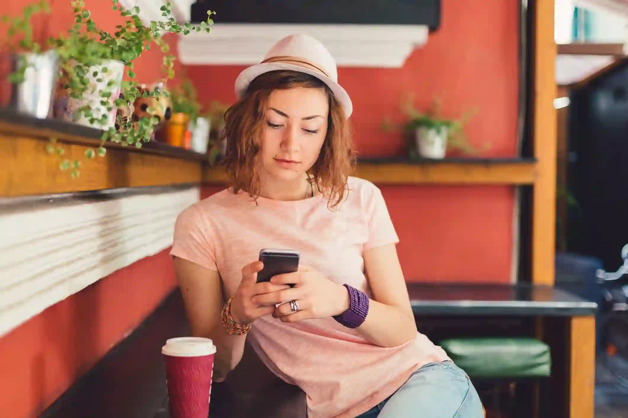 Woman having a cup of coffee while browse her cellphone