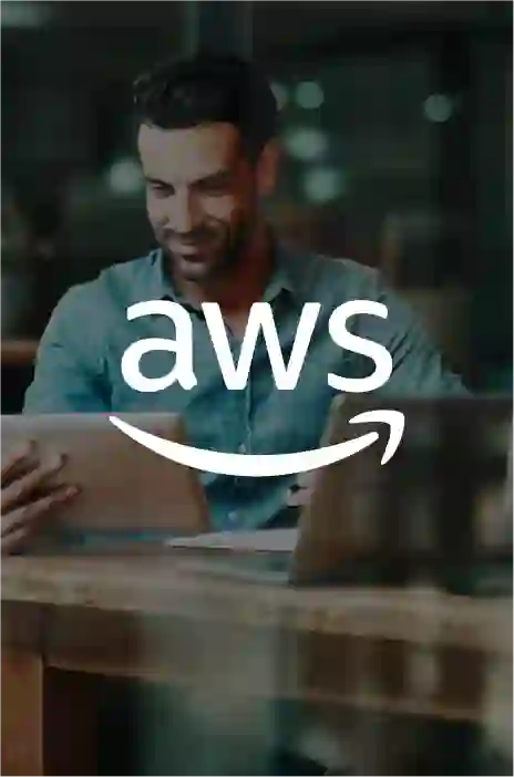 Aws logo in focus and a man working on his tablet in the background