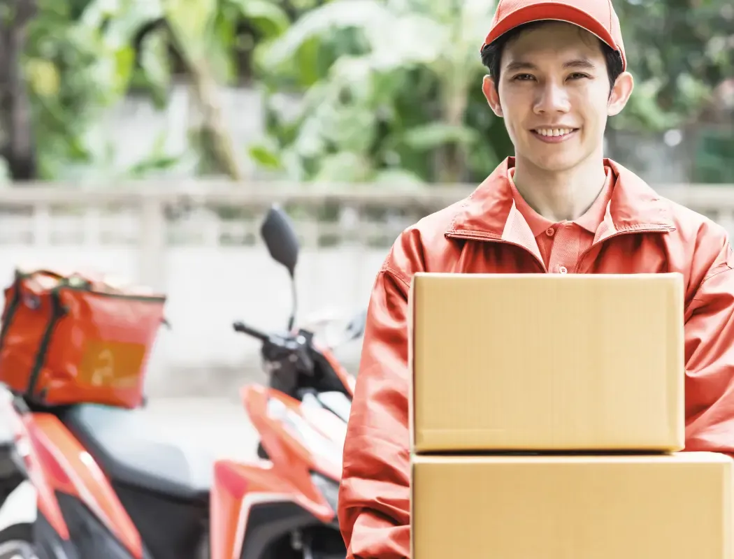 พนักงานส่งของในเครื่องแบบสีส้มส่งพัสดุถึงจุดหมายปลายทาง
