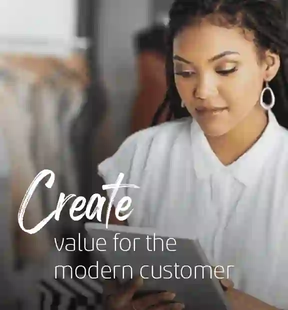 African saleswoman working on a tablet in a clothing store, illustrating TP’s Retail and E-commerce solutions.