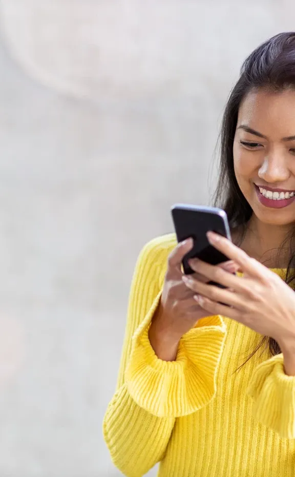 Smiling young Asian girl browsing her smartphone