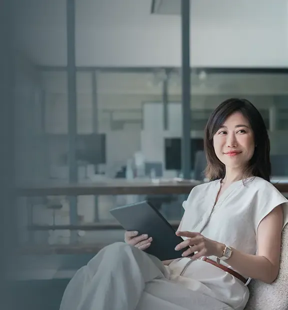 Asian businesswoman reading comfortably on her tablet..