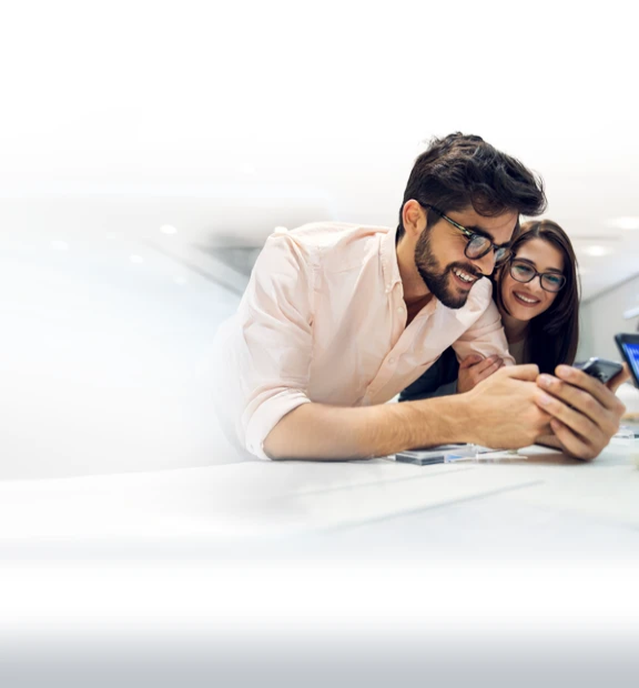 AI by TP displayed over a couple testing a smartphone in a store.