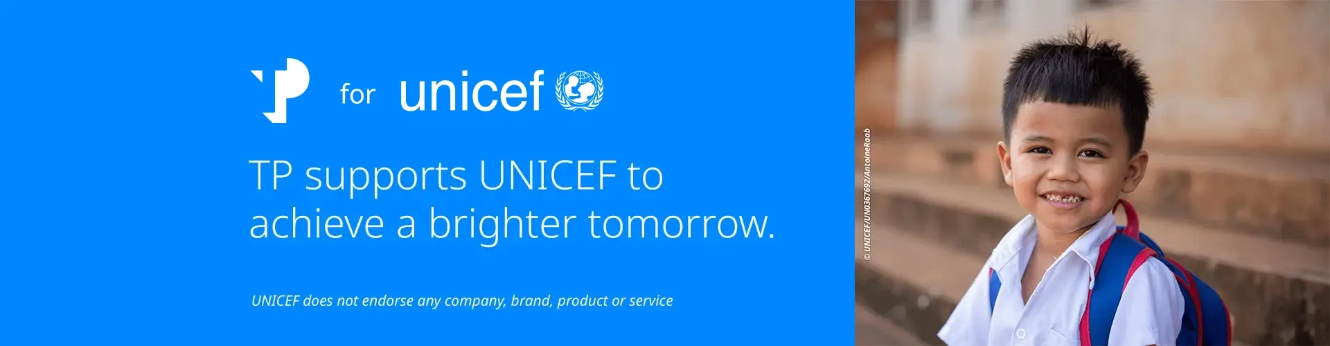 Smiling young boy, next to a blue UNICEF banner with the message supporting a brighter tomorrow.