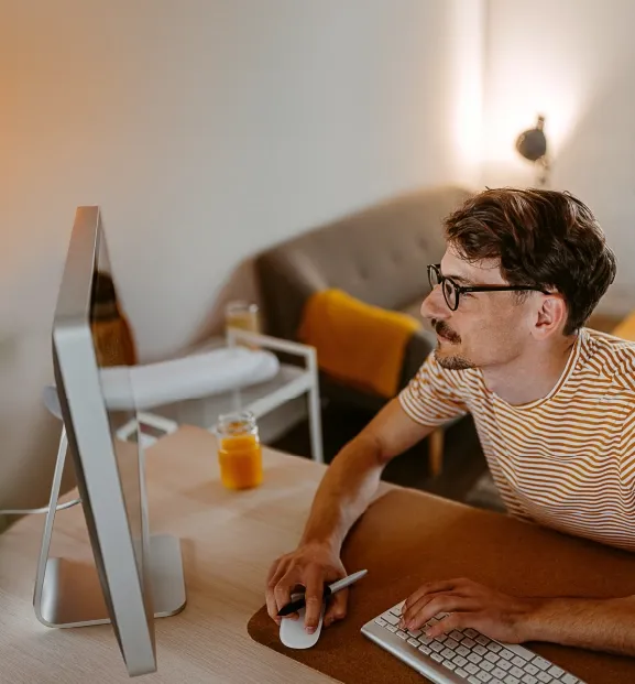 Professional working on a desktop computer from a home office.