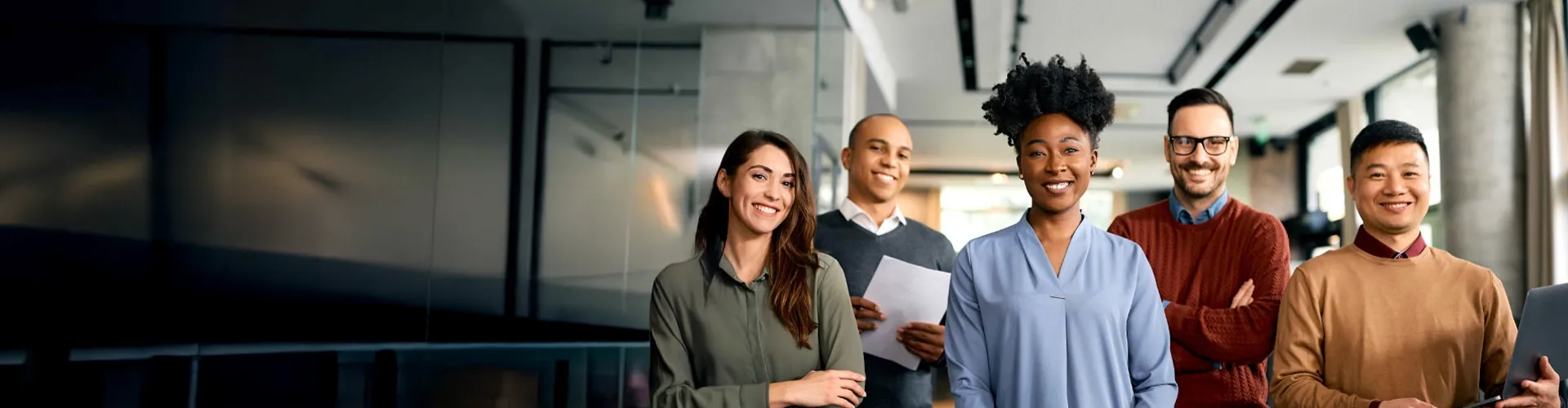 Smiling business people in a modern office staring the camera for a picture