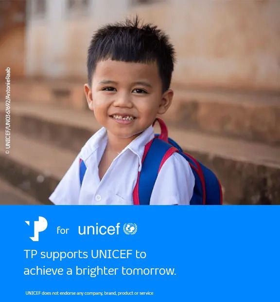 Smiling young boy, next to a blue UNICEF banner with the message supporting a brighter tomorrow.