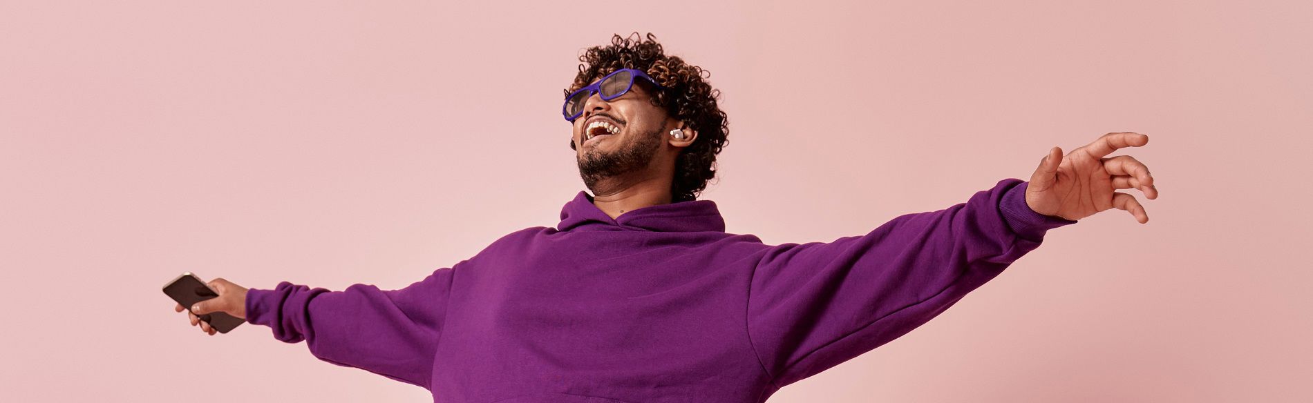 Man smiles and dances while listening to music