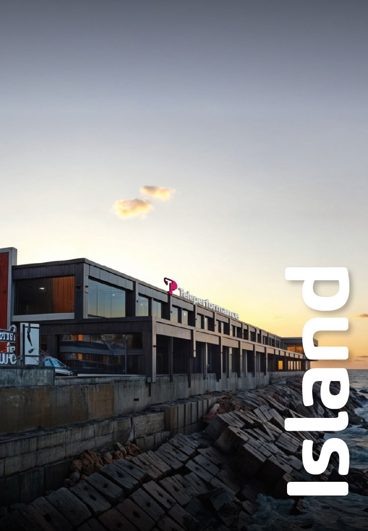 A long, rectangular building with large windows lines a rocky coastline at sunset. the word "island" is prominently displayed vertically in white text on the right side. A long, rectangular building with large windows lines a rocky coastline at sunset. the word "island" is prominently displayed vertically in white text on the right side.