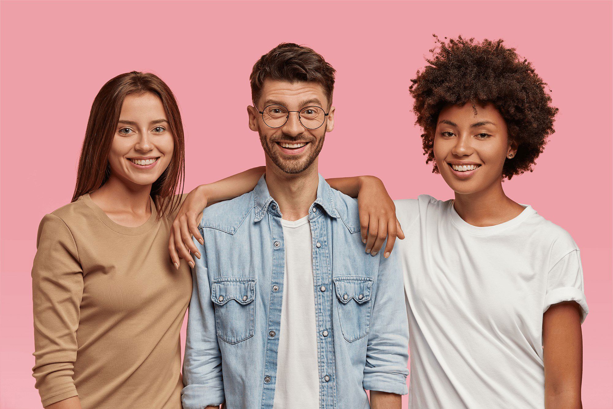 Three smiling TP colleagues standing together against a pink background.