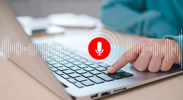 Person using laptop with voice input feature activated, highlighted by red microphone icon and sound wave graphics — illustrating modern voice recognition technology for virtual assistants, transcription, and accessibility tools. Person using laptop with voice input feature activated, highlighted by red microphone icon and sound wave graphics — illustrating modern voice recognition technology for virtual assistants, transcription, and accessibility tools.