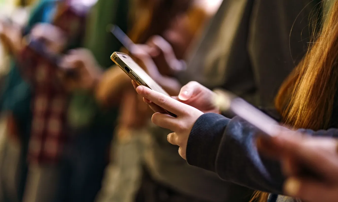 People using smartphones, representing real time trust and safety in digital ecosystems.