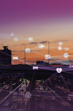 City skyline and highway at sunset with glowing digital lines and icons symbolizing connected technology and infrastructure.