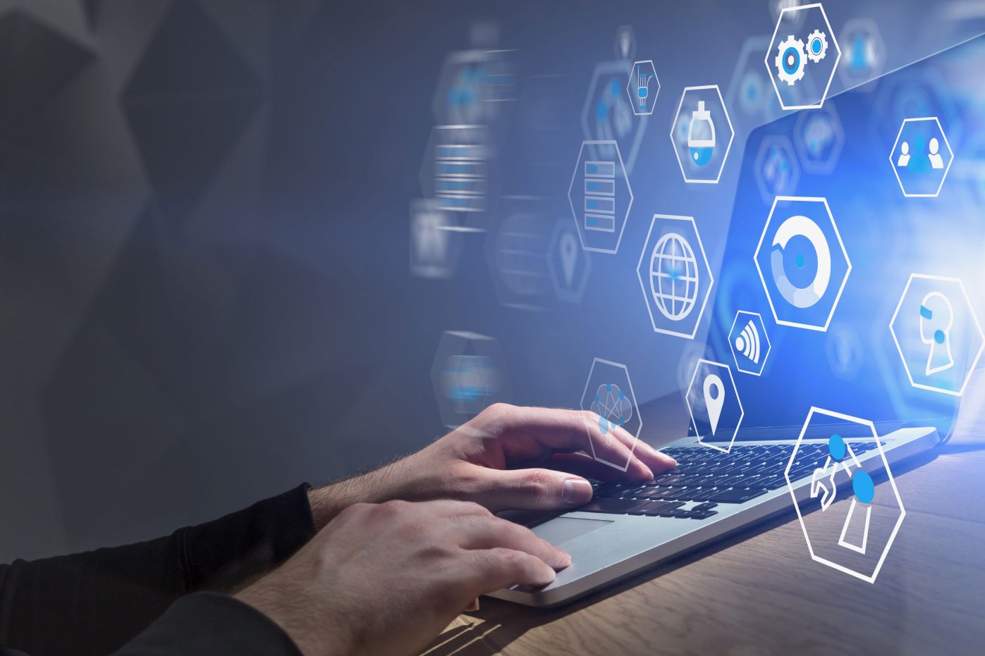 TP employee working on a laptop with digital technology icons displayed.