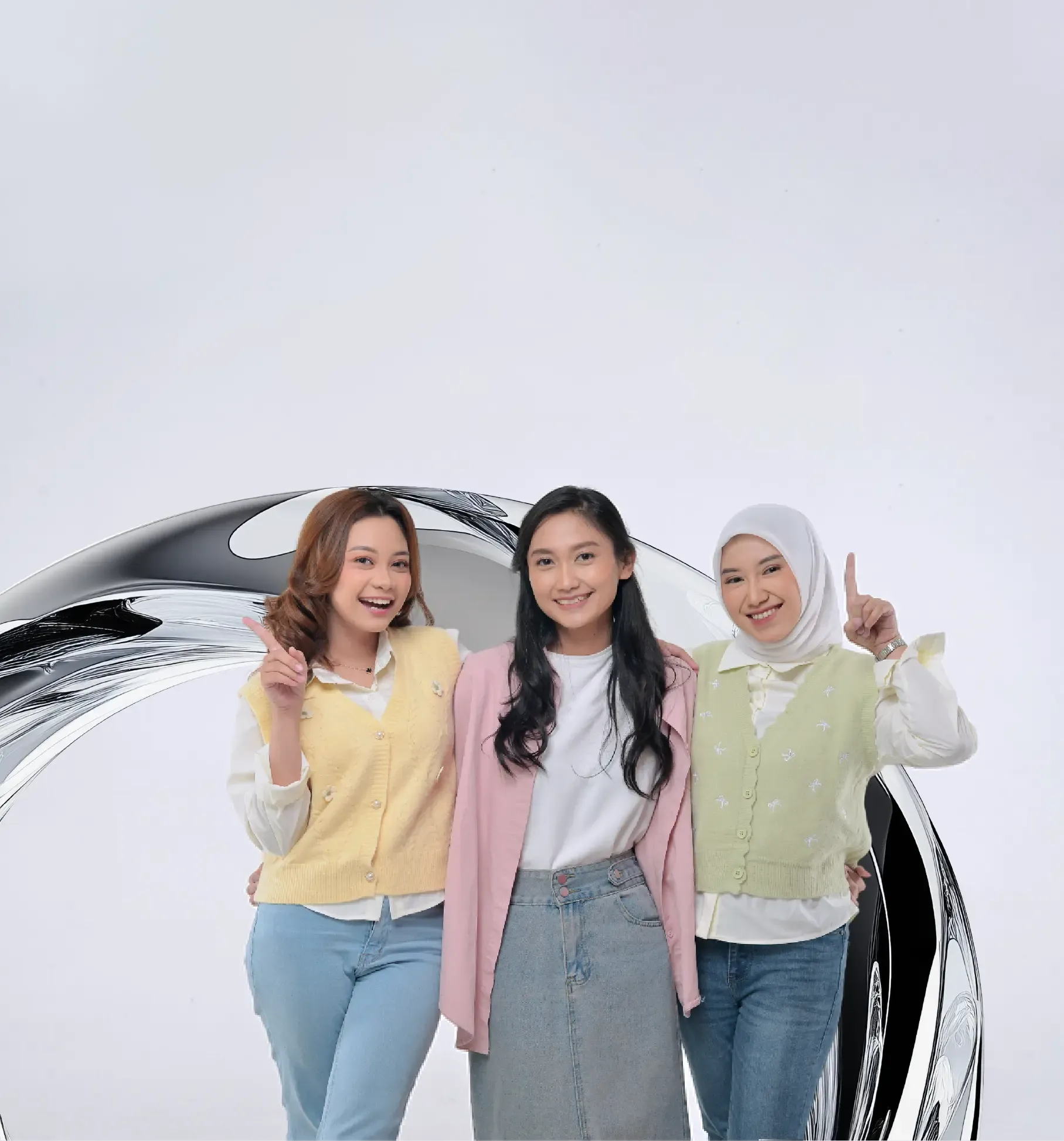 Three diverse young women smile and pose together cheerfully.
