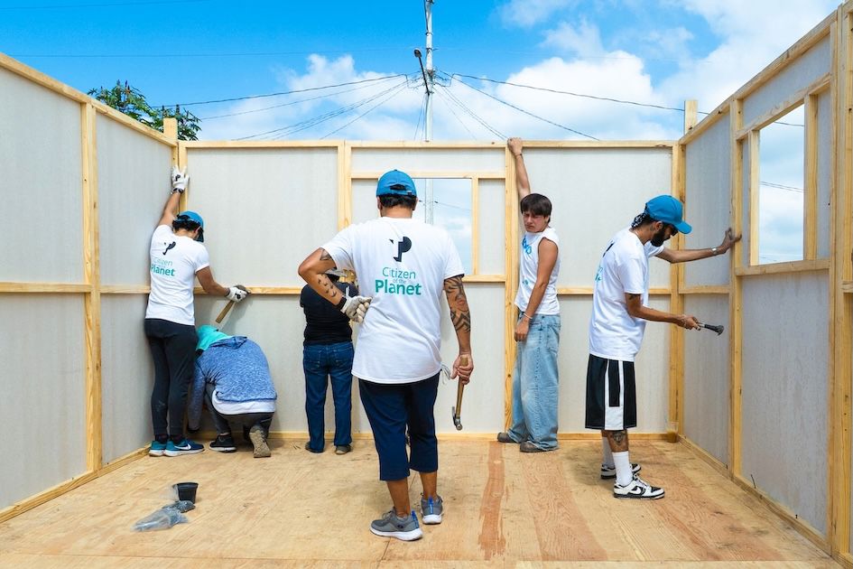 Personas voluntarias de TP construyendo una vivienda junto a integrantes de la comunidad.