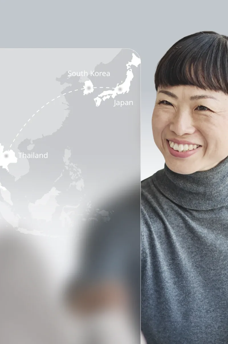 Smiling woman with a map showing a “cultural bridge” connecting Thailand, South Korea, and Japan.