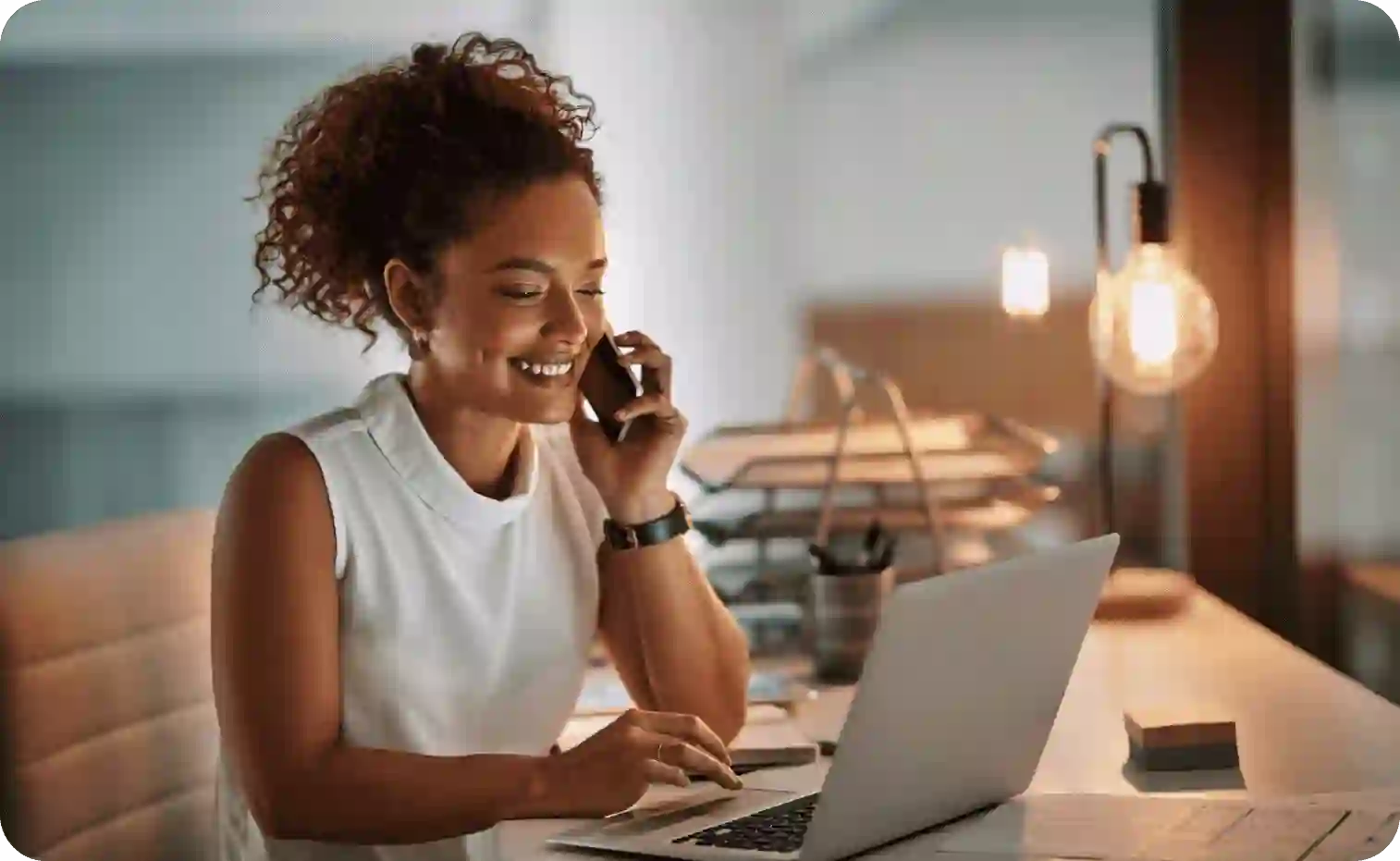Business woman talking on the phone while working on her laptop