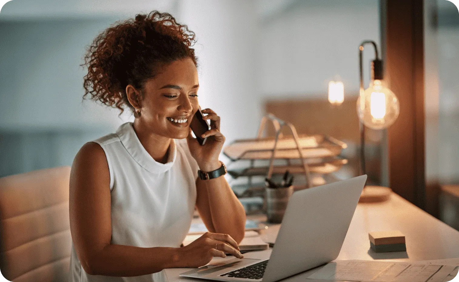 Business woman talking on the phone while working on her laptop