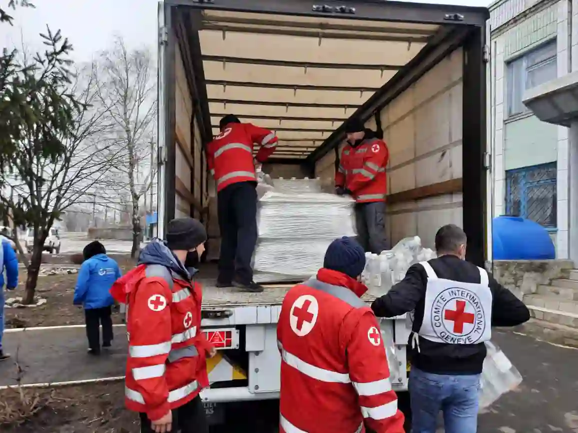 Red Cross workers unloading humanitarian aid supplies from a truck to support local communities