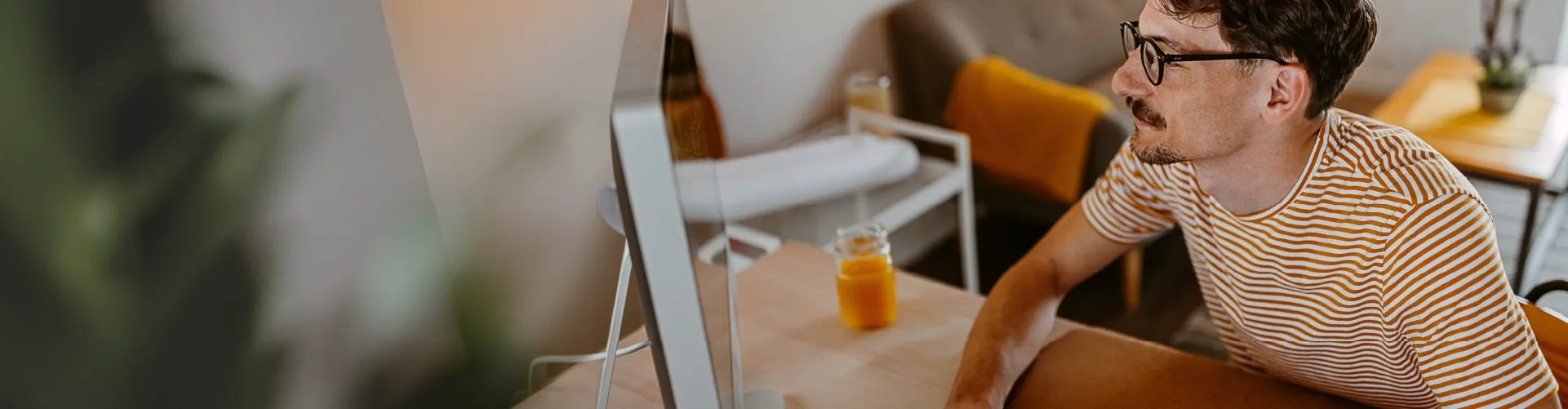 Professional working on a desktop computer from a home office.