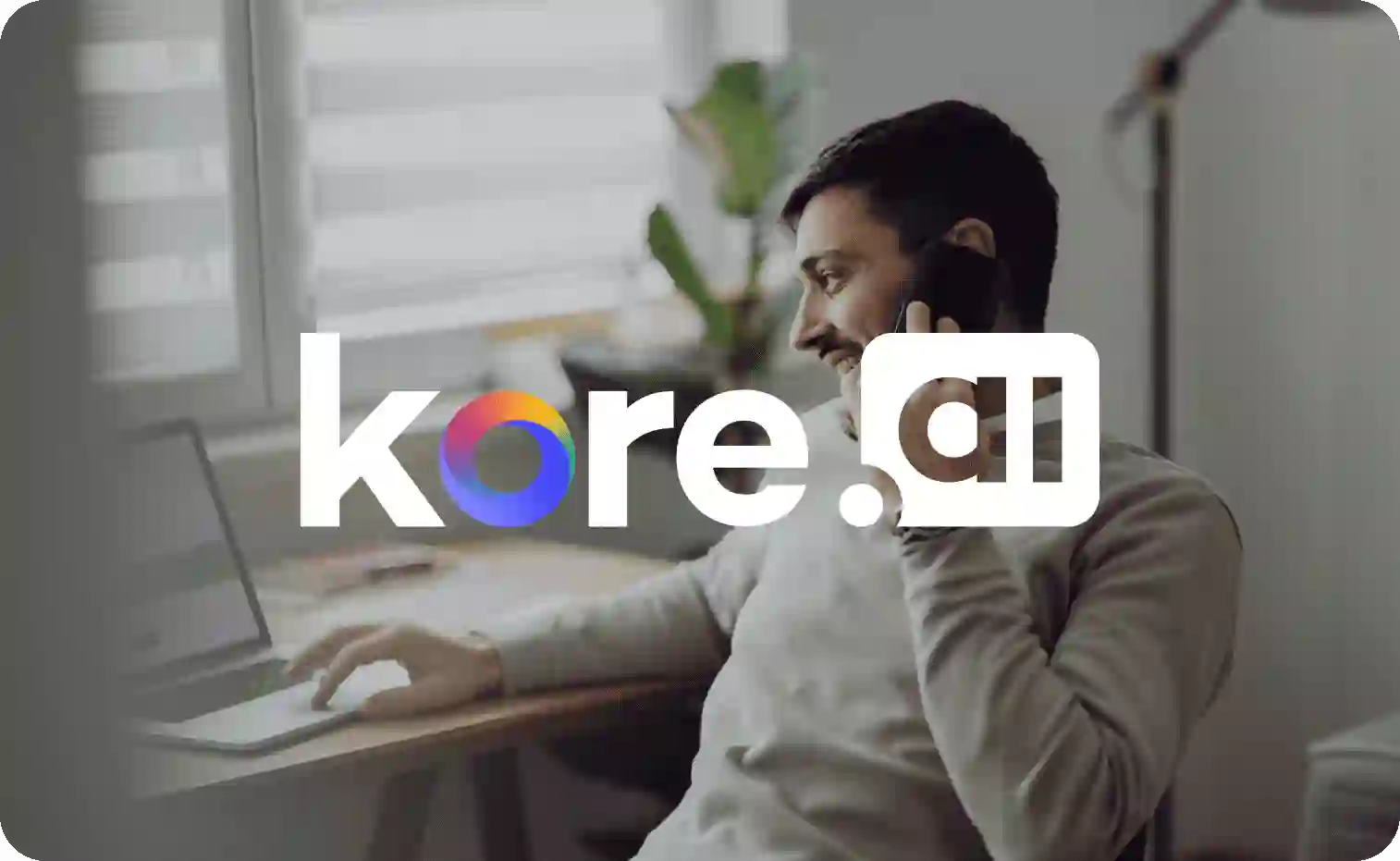 Kore.ai logo in focus with a man talking on the phone in the background