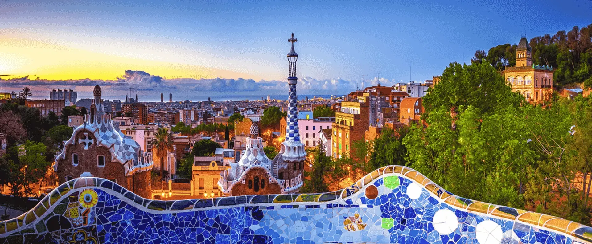 Panoramic view of Barcelona city from Park Güell, showcasing urban landscape and greenery.